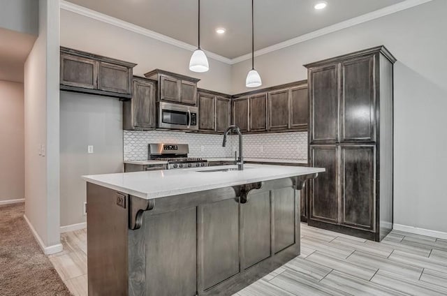kitchen featuring a sink, appliances with stainless steel finishes, dark brown cabinetry, and tasteful backsplash