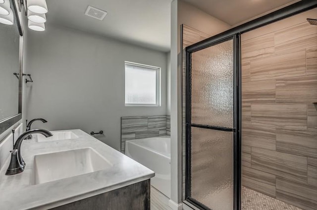 bathroom with visible vents, a sink, a bath, and a shower stall