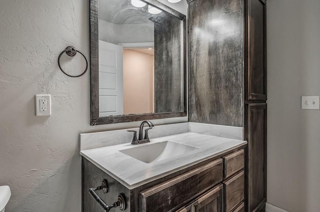 bathroom featuring vanity and a textured wall