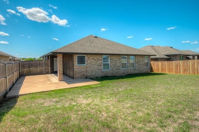 rear view of property featuring a fenced backyard, a patio, a lawn, and brick siding