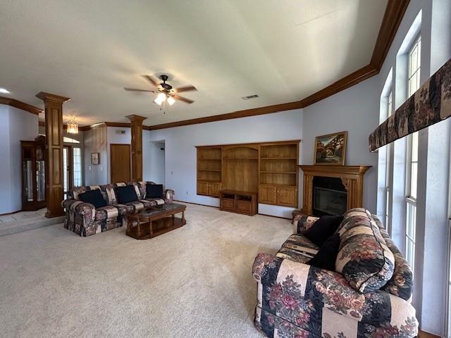 living room featuring ceiling fan, decorative columns, ornamental molding, and light carpet