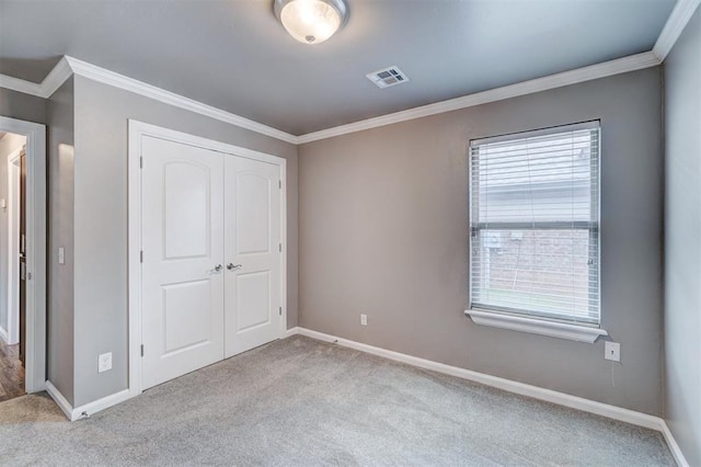 unfurnished bedroom with crown molding, baseboards, carpet, and visible vents