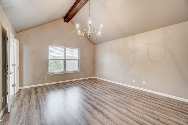 unfurnished room featuring an inviting chandelier, baseboards, lofted ceiling with beams, and wood finished floors