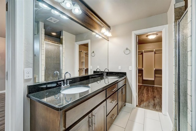 full bathroom featuring tile patterned flooring, a sink, a stall shower, and visible vents