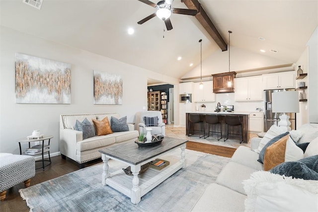 living room with beam ceiling, a ceiling fan, light wood finished floors, recessed lighting, and high vaulted ceiling