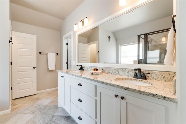 bathroom featuring baseboards, a shower stall, and double vanity