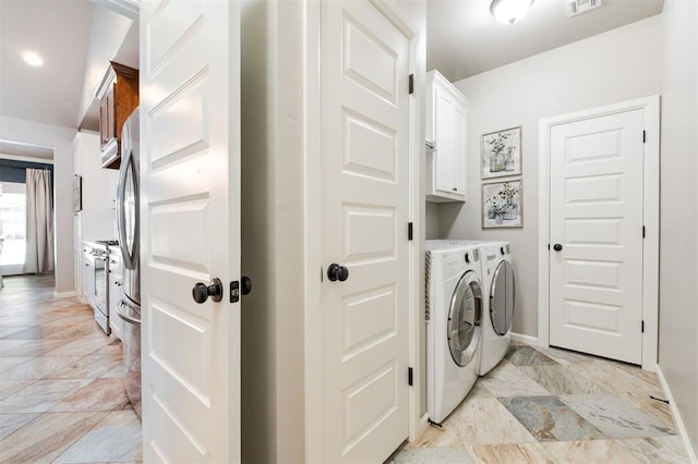 laundry room with cabinet space, washer and clothes dryer, and baseboards