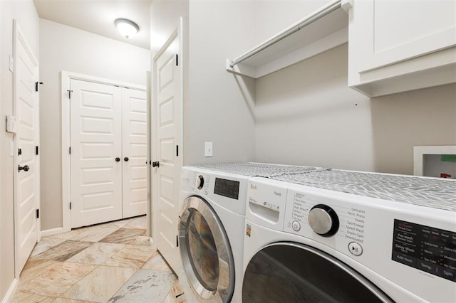 laundry area featuring washing machine and clothes dryer, cabinet space, baseboards, and light marble finish floors
