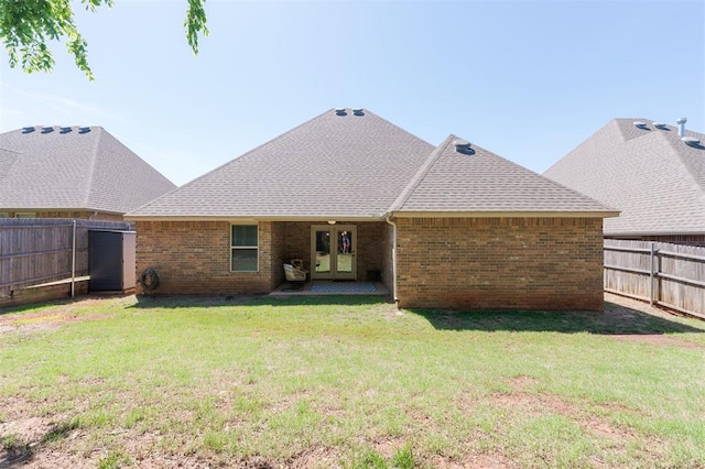 back of house with brick siding, a shingled roof, and french doors