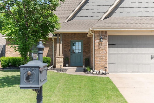 entrance to property with a shingled roof, a lawn, brick siding, and an attached garage