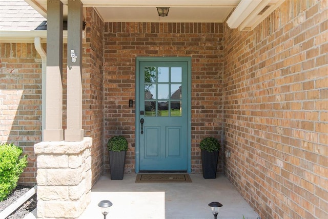 view of exterior entry with brick siding