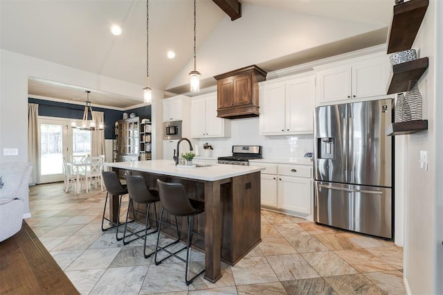 kitchen with stainless steel appliances, a sink, backsplash, light countertops, and a kitchen breakfast bar