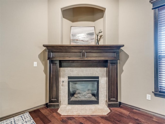interior details with a fireplace with flush hearth and wood finished floors