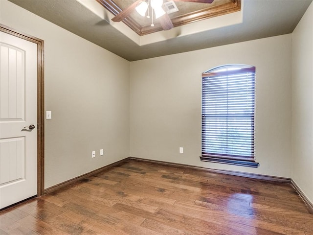 spare room featuring ceiling fan, plenty of natural light, wood finished floors, and visible vents