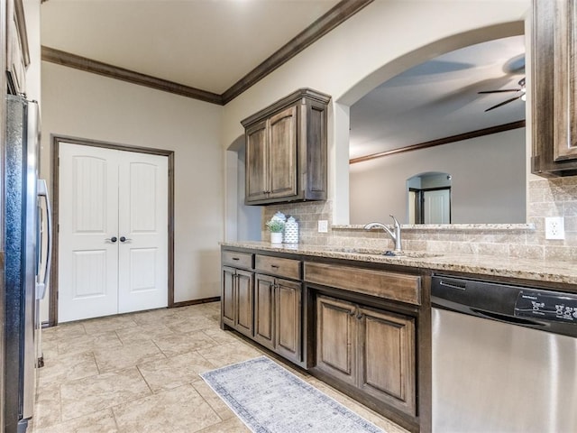 kitchen featuring crown molding, stainless steel appliances, arched walkways, and a sink