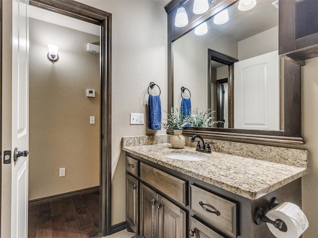 bathroom with vanity, baseboards, and wood finished floors