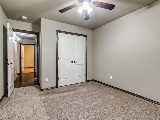 unfurnished bedroom with baseboards, ceiling fan, carpet, and a closet