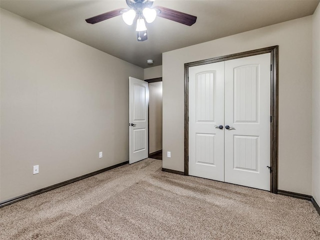 unfurnished bedroom with light colored carpet, a ceiling fan, baseboards, and a closet