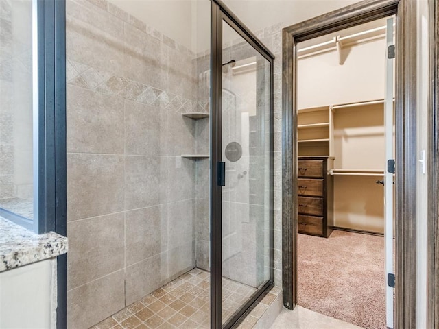 full bathroom with a walk in closet and a stall shower
