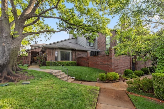 view of front of home featuring a front lawn and brick siding