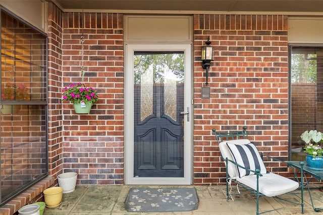 view of exterior entry featuring brick siding