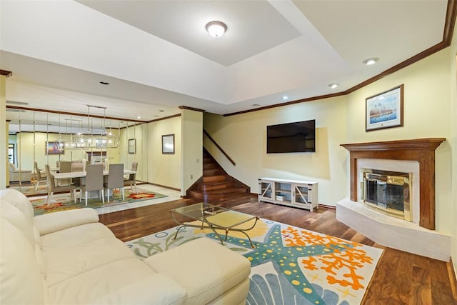 living room featuring stairs, ornamental molding, and wood finished floors