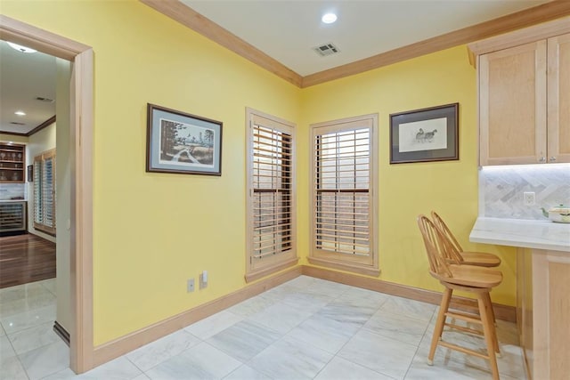 interior space with crown molding, baseboards, and visible vents