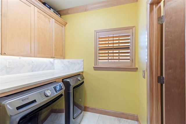 laundry area with cabinet space, separate washer and dryer, baseboards, and light tile patterned floors