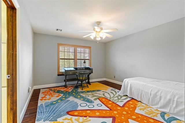 bedroom with visible vents, a ceiling fan, dark wood-style flooring, and baseboards