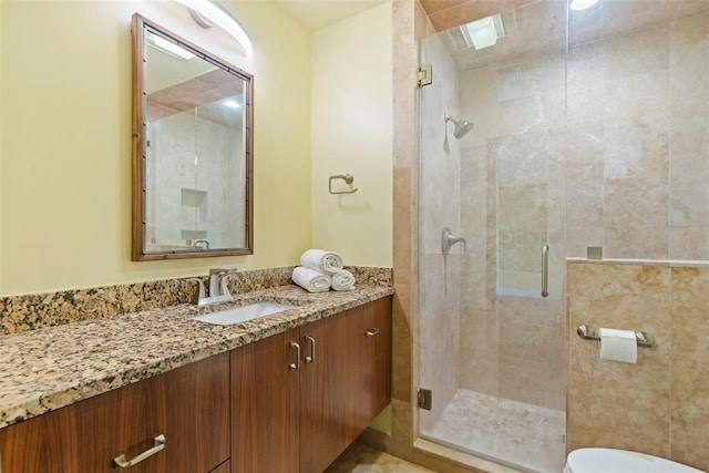 bathroom featuring vanity, toilet, and a shower stall