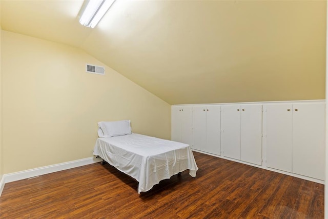 bedroom featuring baseboards, visible vents, dark wood-style floors, and lofted ceiling