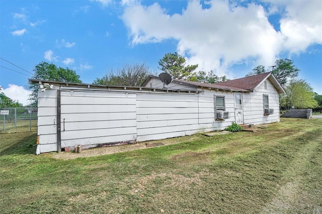 view of home's exterior with fence, a lawn, and cooling unit