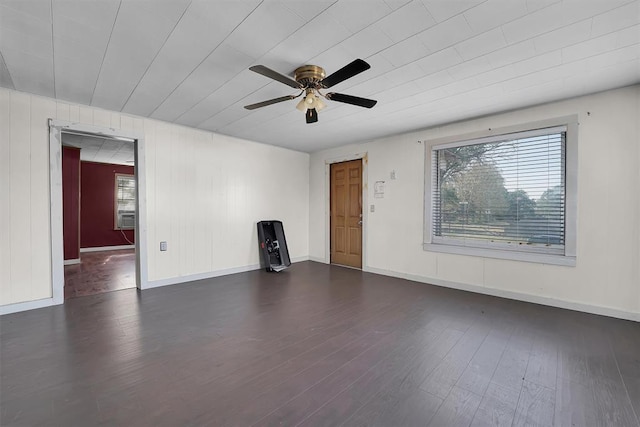 unfurnished living room featuring baseboards, a ceiling fan, and dark wood-style floors