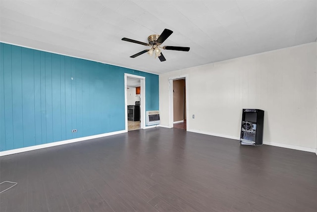 unfurnished living room featuring heating unit, baseboards, a ceiling fan, and wood finished floors