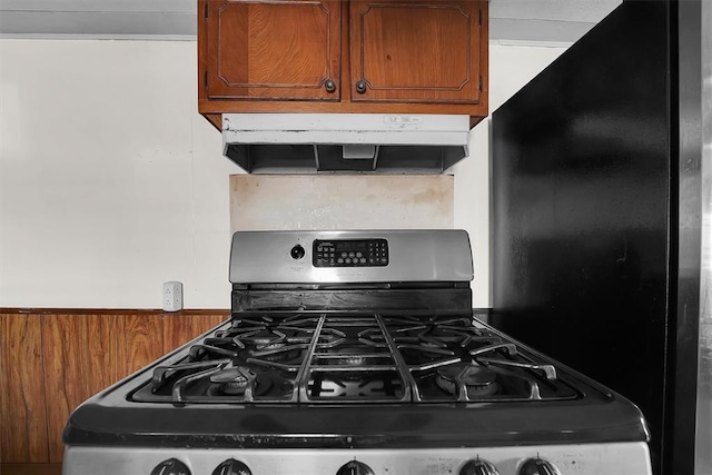 kitchen featuring stainless steel range with gas stovetop, brown cabinets, and under cabinet range hood