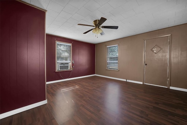 empty room with a ceiling fan, baseboards, a healthy amount of sunlight, and wood finished floors