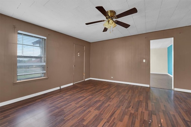 spare room featuring baseboards, ceiling fan, and wood finished floors