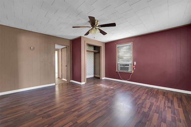 unfurnished bedroom with a ceiling fan, wood finished floors, baseboards, cooling unit, and a closet