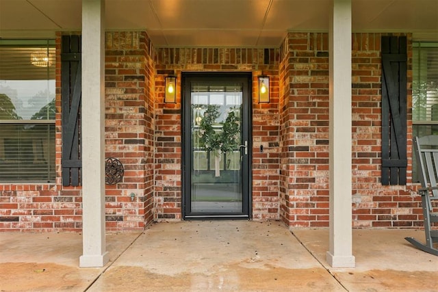 entrance to property featuring brick siding