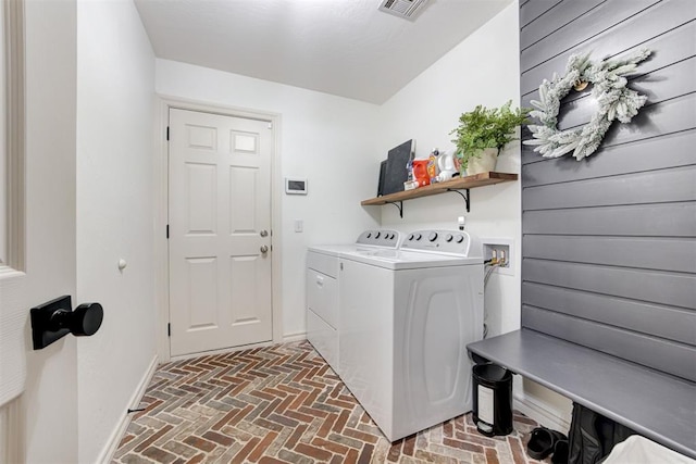 washroom with laundry area, independent washer and dryer, brick floor, and visible vents