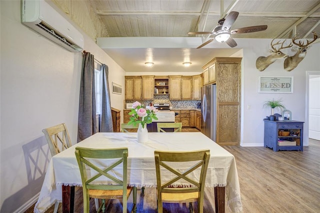 dining room with visible vents, light wood-style floors, baseboards, ceiling fan, and a wall mounted AC