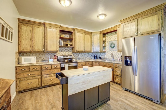 kitchen featuring light countertops, appliances with stainless steel finishes, open shelves, and light wood-type flooring
