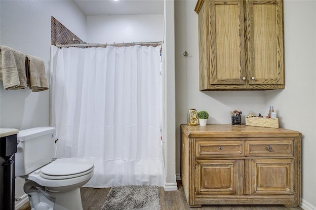 full bath with toilet, curtained shower, and wood finished floors