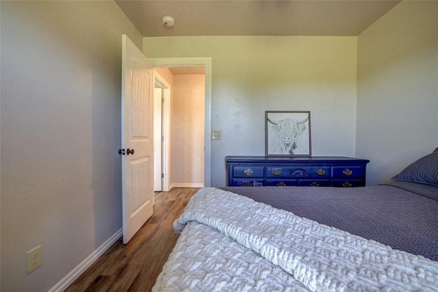 bedroom featuring baseboards and wood finished floors