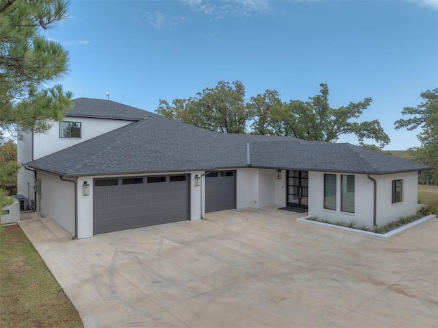 single story home with concrete driveway, stucco siding, a shingled roof, and a garage