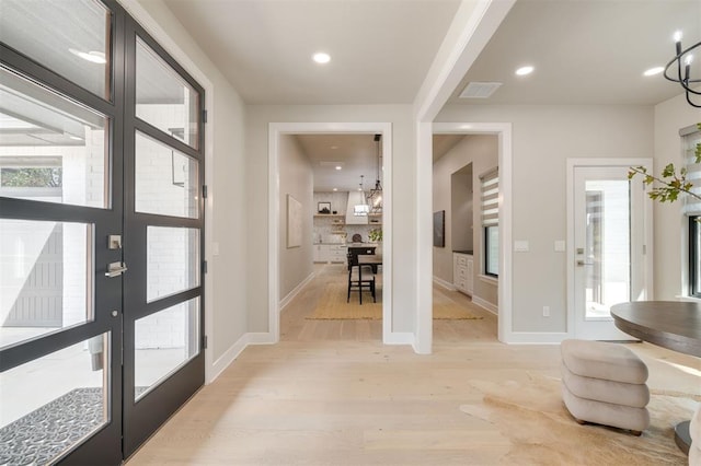 foyer with recessed lighting, baseboards, light wood finished floors, and visible vents