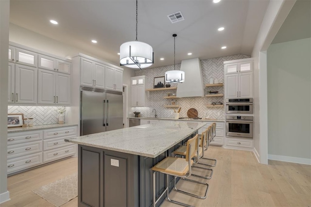 kitchen with white cabinets, open shelves, appliances with stainless steel finishes, tasteful backsplash, and visible vents