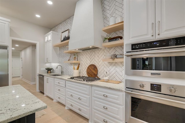 kitchen with open shelves, appliances with stainless steel finishes, a sink, decorative backsplash, and custom range hood