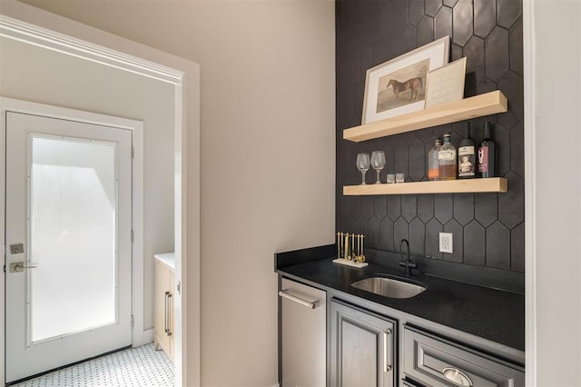 bar with indoor wet bar, decorative backsplash, a sink, and light floors