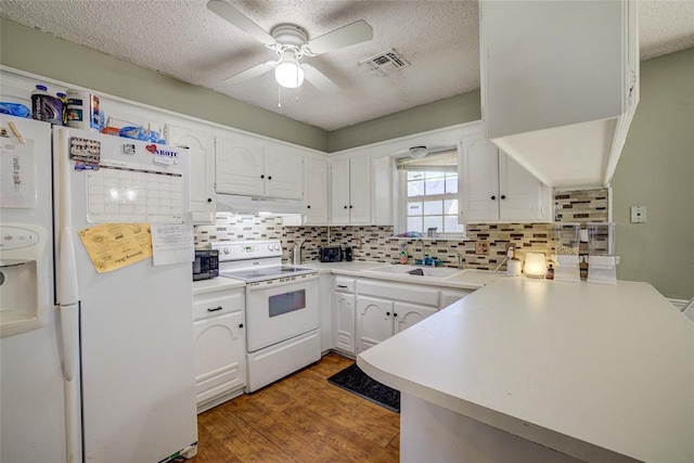 kitchen featuring a ceiling fan, a textured ceiling, a sink, a peninsula, and white appliances